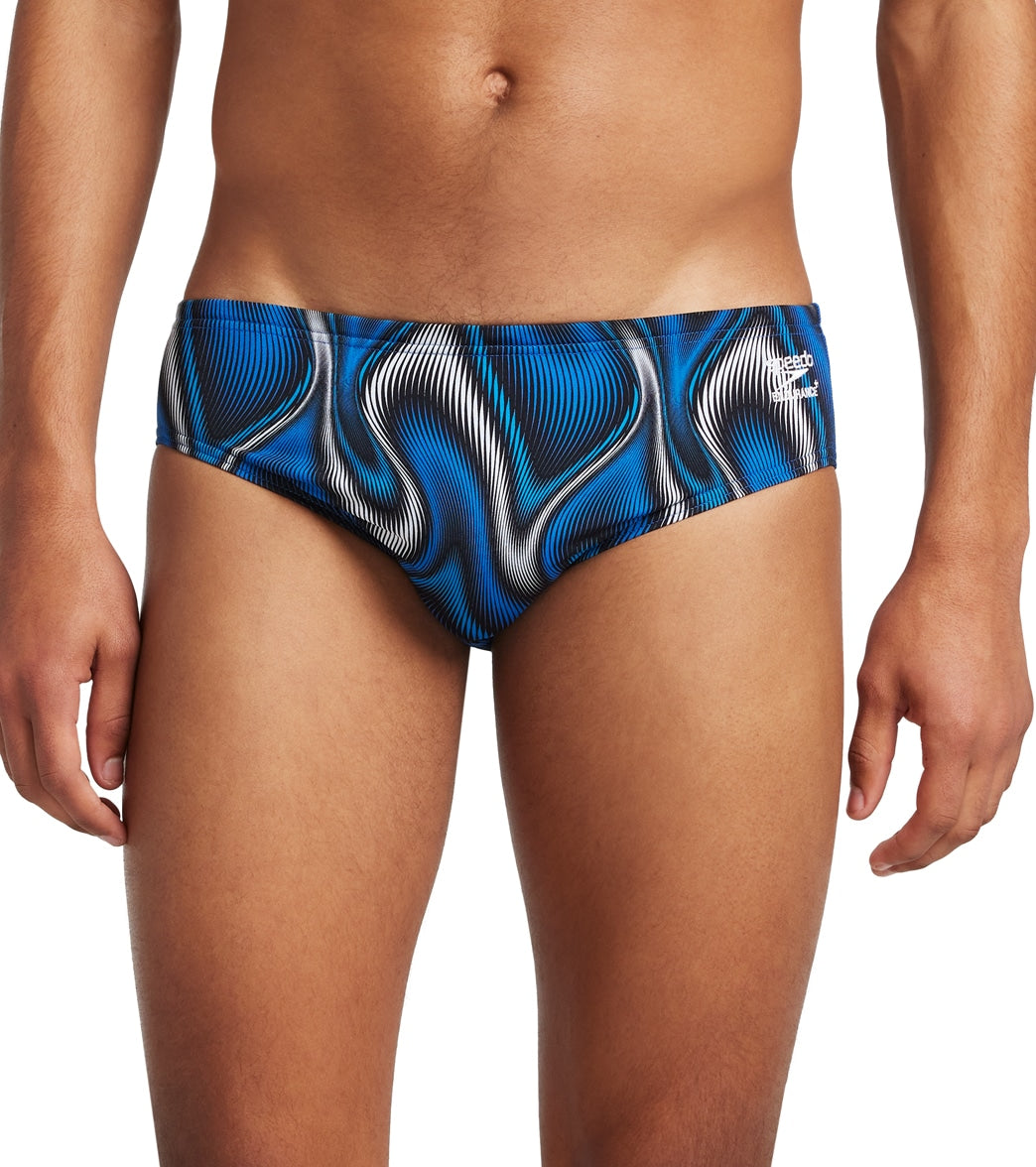 A pair of men's swim briefs by Speedo. The swimwear features a distinctive blue and black wavy pattern and a sleek, form-fitting design.
