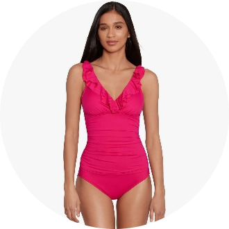 Woman wearing a vibrant pink one-piece swimsuit with ruffled neckline and ruched detailing. The swimwear is designed for comfort and style, perfect for competitive swimming or leisure.