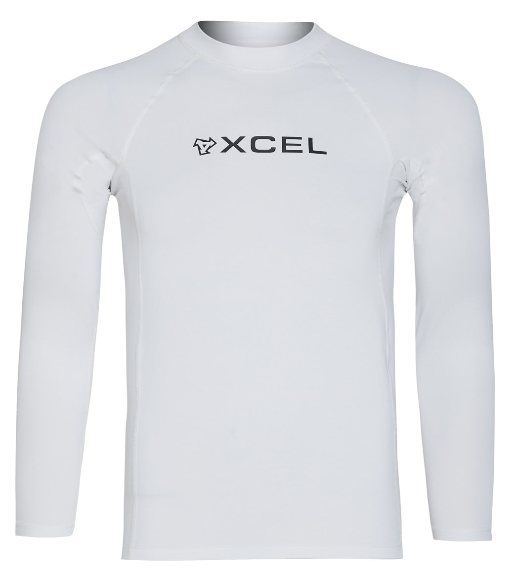 A white long-sleeve rash guard by the brand XCEL. The focus is on the design, fit, and brand logo prominently featured on the front of the garment.